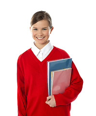 Image showing Cheerful schoolgirl holding books