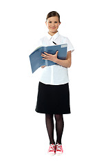 Image showing Full length portrait of smiling girl doing homework