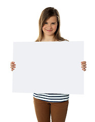 Image showing Smiling teenager showing blank white billboard