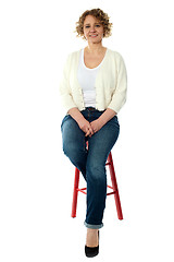 Image showing Confident smiling woman sitting on stool