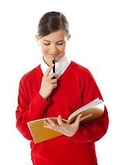 Image showing Girl thinking and looking into her notebook