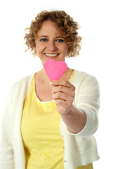 Image showing Woman showing pink paper hear to camera