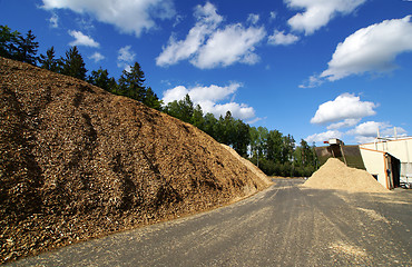 Image showing bio power plant with storage of wooden fuel against blue sky