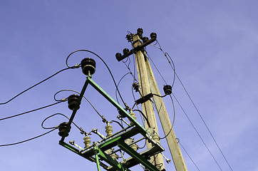 Image showing Electricity poles and wires on blue sky background 