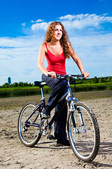 Image showing beautiful woman with bicycle at the sea