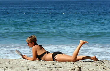 Image showing Woman reading on the beach
