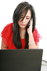 Image showing Serious business woman looking at laptop screen while talking on