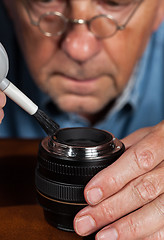 Image showing Senior craftsman cleaning lens