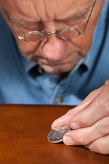 Image showing Senior man examining half dollar