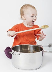 Image showing baby with big cooking pot and wooden spoon