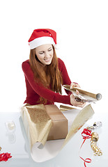 Image showing young woman is packing  present for christmas isolated