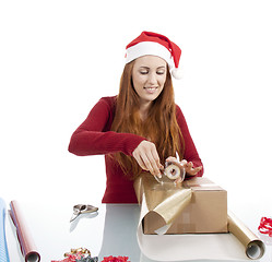 Image showing young woman is packing  present for christmas isolated