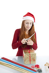 Image showing young woman is packing  present for christmas isolated