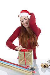 Image showing young woman is packing  present for christmas isolated