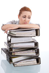 Image showing business woman in office looks at unbelievable folder stack