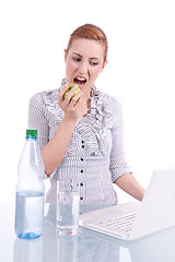Image showing young business woman on computer with snack isolated 