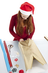 Image showing young woman is packing  present for christmas isolated