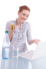 Image showing young business woman on computer with snack isolated 