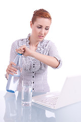 Image showing young business woman on computer with snack isolated 