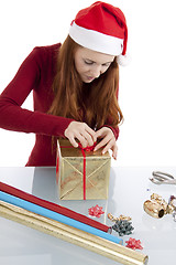 Image showing young woman is packing  present for christmas isolated