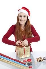 Image showing young woman is packing  present for christmas isolated