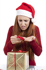 Image showing young woman is packing  present for christmas isolated