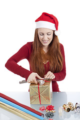 Image showing young woman is packing  present for christmas isolated