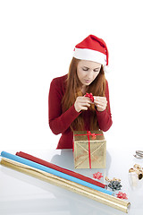 Image showing young woman is packing  present for christmas isolated