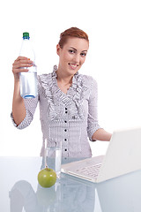 Image showing young business woman on computer with snack isolated 