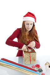 Image showing young woman is packing  present for christmas isolated