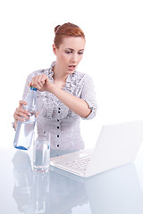 Image showing young business woman on computer with snack isolated 