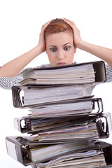 Image showing business woman in office looks at unbelievable folder stack