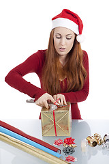 Image showing young woman is packing  present for christmas isolated