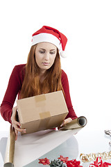 Image showing young woman is packing  present for christmas isolated