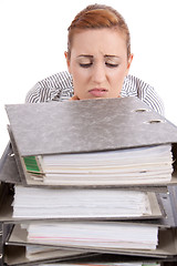 Image showing business woman in office looks at unbelievable folder stack