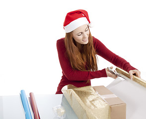 Image showing young woman is packing  present for christmas isolated