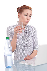 Image showing young business woman on computer with snack isolated 