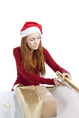 Image showing young woman is packing  present for christmas isolated