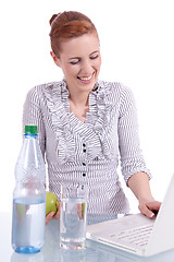 Image showing young business woman on computer with snack isolated 