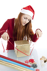 Image showing young woman is packing  present for christmas isolated