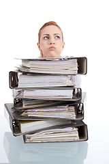 Image showing business woman in office looks at unbelievable folder stack