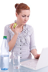 Image showing young business woman on computer with snack isolated 