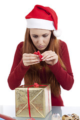 Image showing young woman is packing  present for christmas isolated