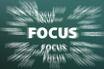 Image showing Focus word with motion rays on green chalkboard background 