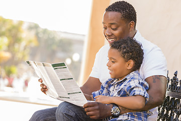 Image showing Mixed Race Father and Son Reading Park Brochure Outside