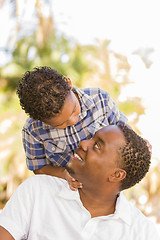 Image showing Mixed Race Father and Son Playing Piggyback in Park