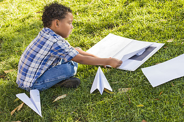 Image showing Mixed Race Boy Learning How to Fold Paper Airplanes