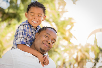 Image showing Mixed Race Father and Son Playing Piggyback in Park