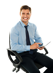 Image showing Seated young executive using tablet pc