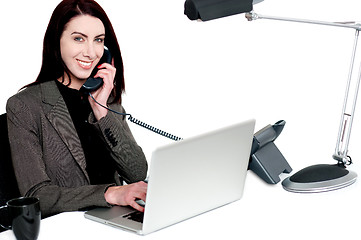 Image showing Female operator talking on phone and smiling